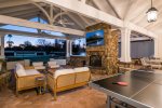Extended covered patio with outdoor fireplace and wall TV